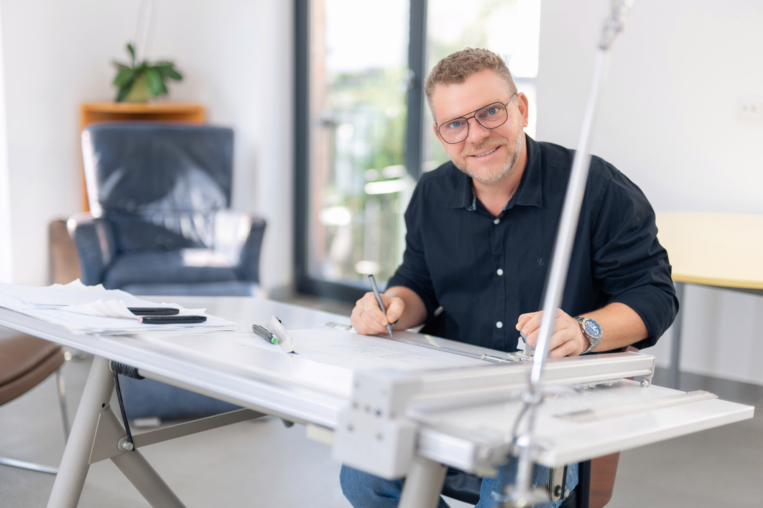 Foto von Tino Holzhäuser, sitzend an seinem Arbeitsplatz